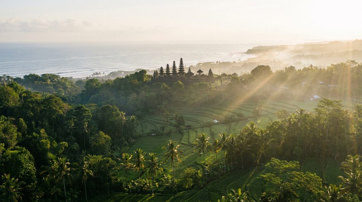 Sweeping view over Bali's jungle valley, temple silhouette and distant coastline